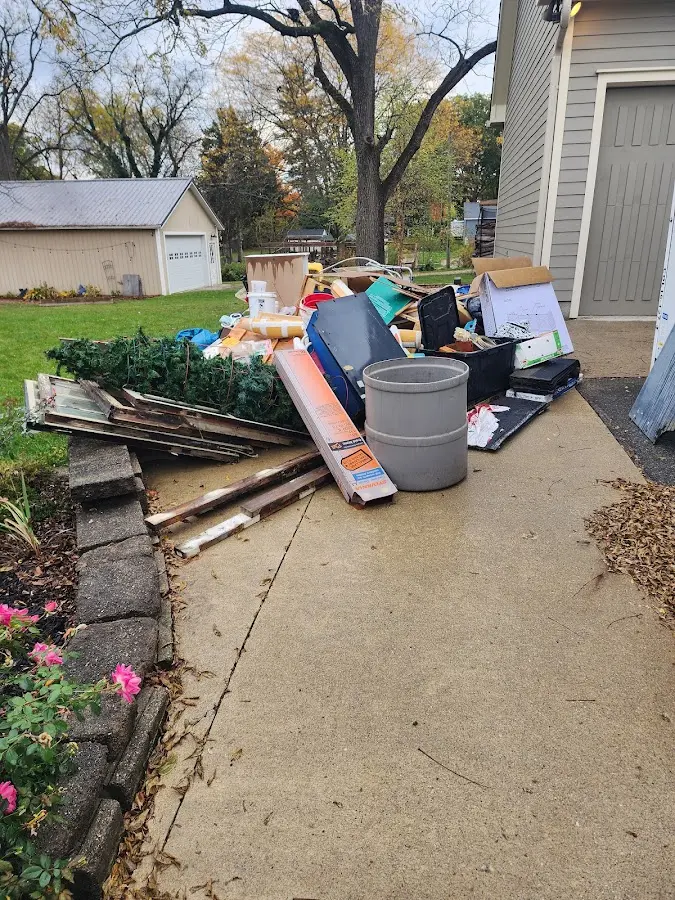 Dumpster being loaded with debris for 12 Yard Dumpster Rental in Plainsboro